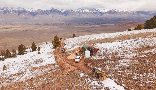 Trucks at a discovery site beneath the snowy mountains