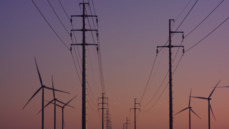 Photograph of power lines with the sunset in the background
