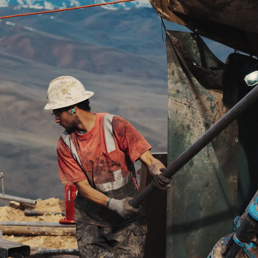 A worker in a hard hat using a drill
